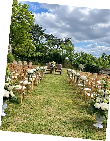Allée de cérémonie en plein air bordée de chaises et de bouquets blancs