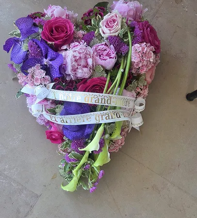 Cœur fleuri de roses et de fleurs pastel avec un ruban