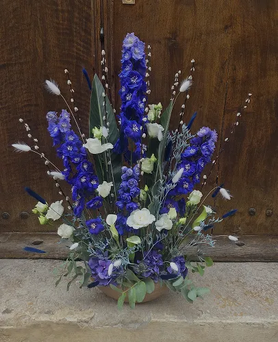 Gerbe funéraire de delphiniums bleus et de fleurs blanches