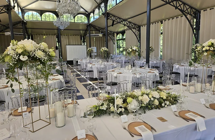 Tables de réception chic fleuries de bouquets blancs et de chandeliers